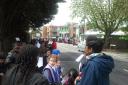 Children from Cranmer and St Thomas of Canterbury primary schools waiting in Cedars Avenue for The Queen