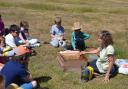 Alison Pelikan on Wimbledon Common showing a beehive to children.