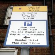 Mike Housden stopped to read a parking sign in Wimbledon