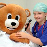 Ruby Casey, 8, checks the ears of her bear patient.