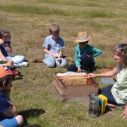 Alison Pelikan on Wimbledon Common showing a beehive to children.