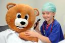 Ruby Casey, 8, checks the ears of her bear patient.