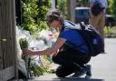 A woman lays flowers in outside the Study Preparatory School in Wimbledon, south-west London