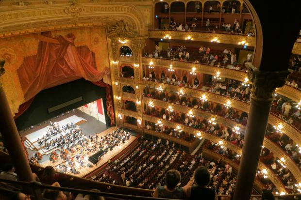 Wimbledon Times: A grand theatre with people watching an orchestra. Credit: Canva