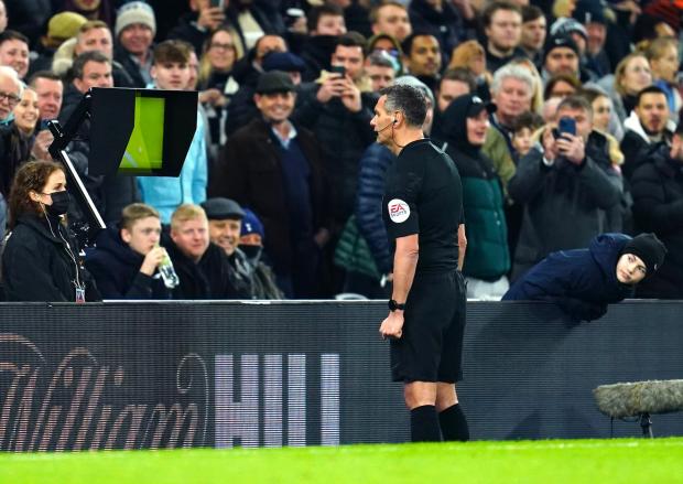 Wimbledon Times: Referee Andre Marriner checks a penalty decision on VAR during the Carabao Cup Semi Final, second leg match at the Tottenham Hotspur Stadium, London.