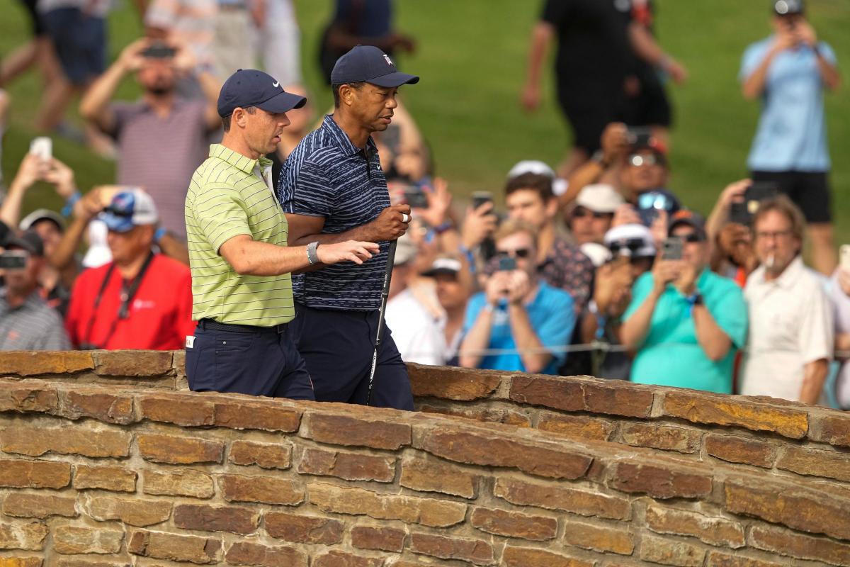 Rory McIlroy walks with Tiger Woods