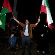 A demonstrator waves Iranian and Palestinian flags during an anti-Israeli gathering at the Felestin (Palestine) Square in Tehran, Iran (Vahid Salemi/AP)