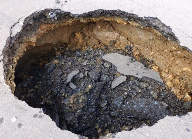 This sinkhole has appeared in the middle of a road in Colliers Wood